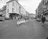 102647 Afbeelding van het drijven van een koppel ganzen door enkele Drentse ganzenhoedsters door de Voorstraat te ...
